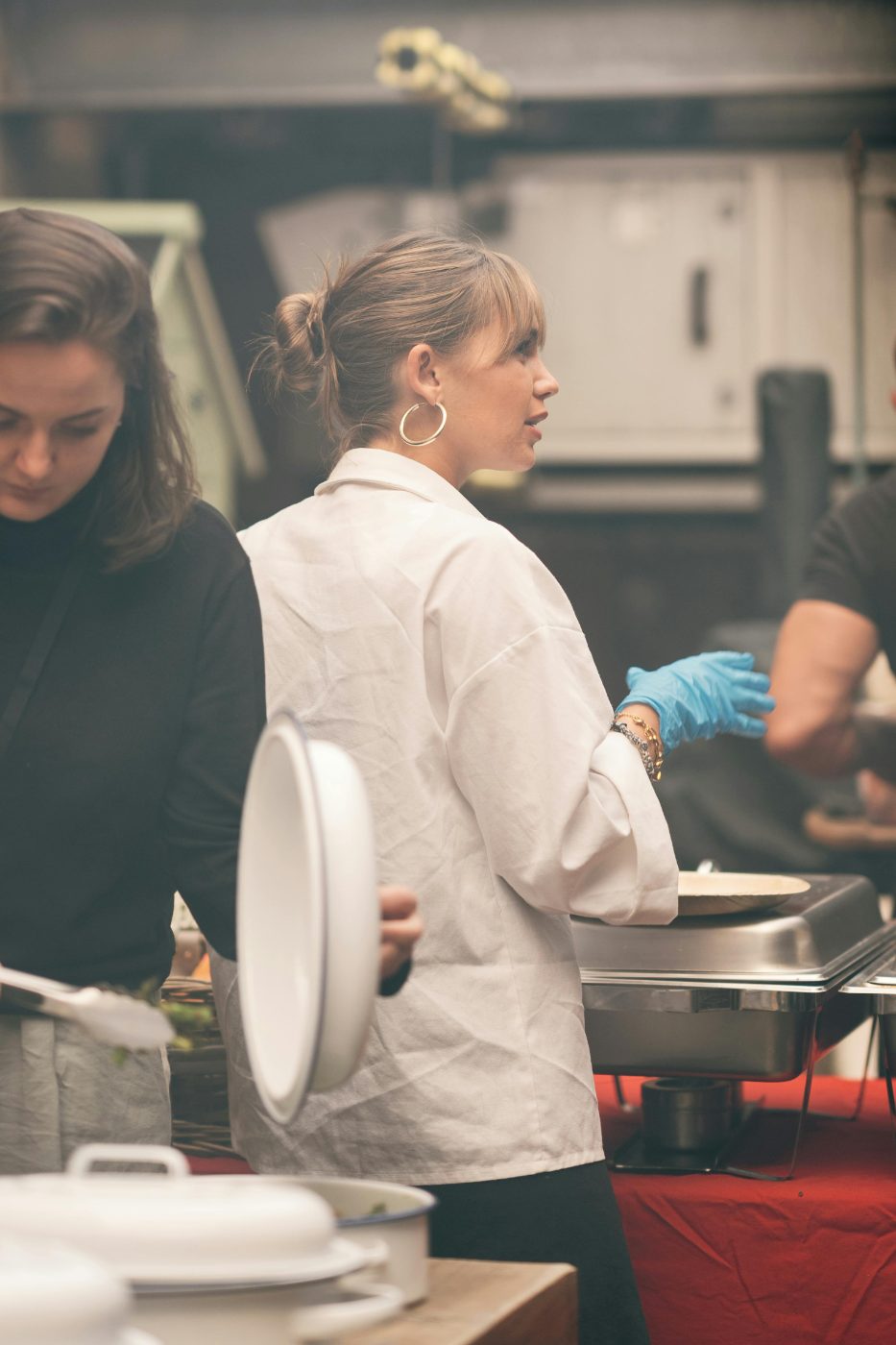 Vrouw in wit koksbuis aan het werk in een keuken